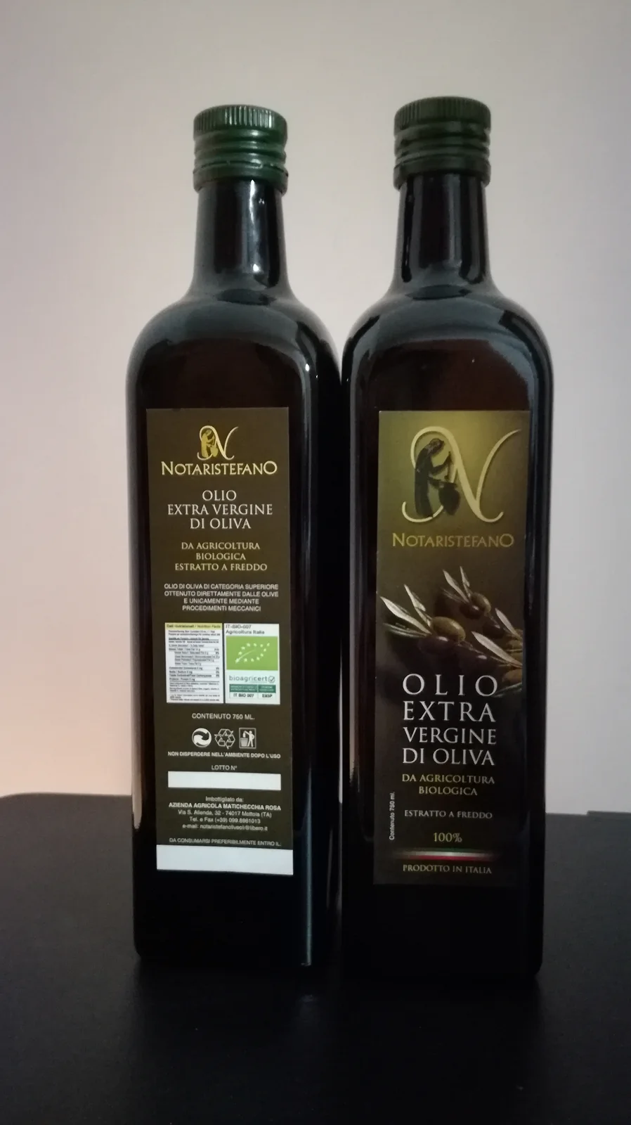 Bottiglie di olio Notaristefano, fronte e retro della confezione nera e oro
